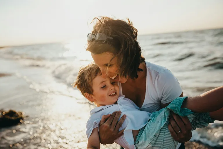 Người mẹ ôm con nhỏ bên bờ biển